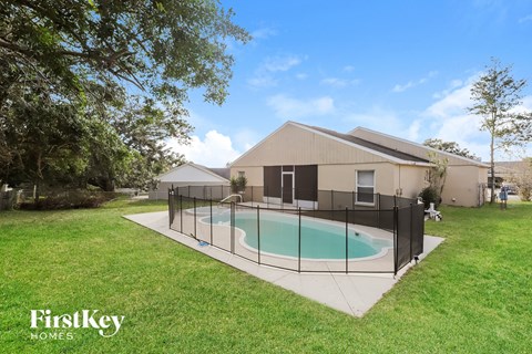 a pool in the backyard of a house with a fence around it
