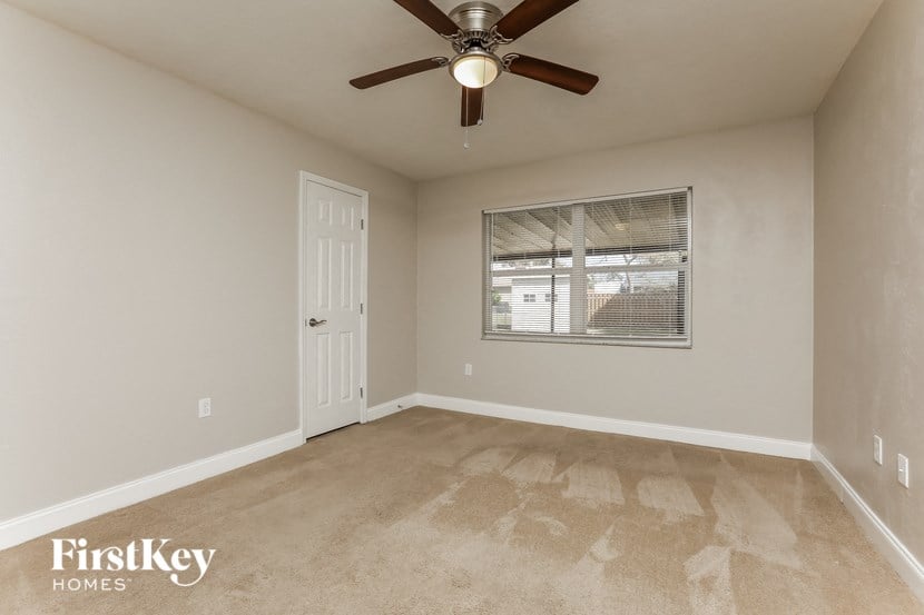 the master bedroom has a ceiling fan and carpeted flooring