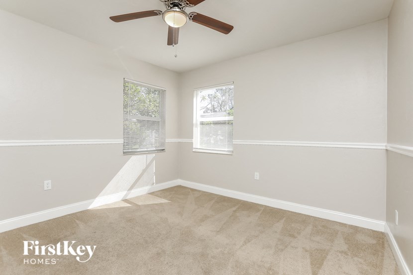 a bedroom with a ceiling fan and a window