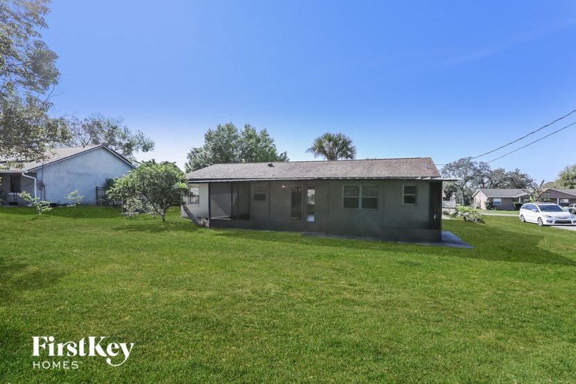 a small house with a grass yard and a blue sky