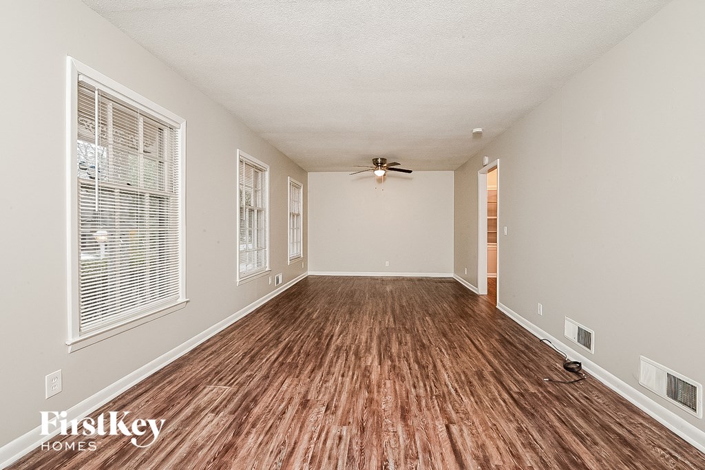 a living room with a hard wood floor and a ceiling fan
