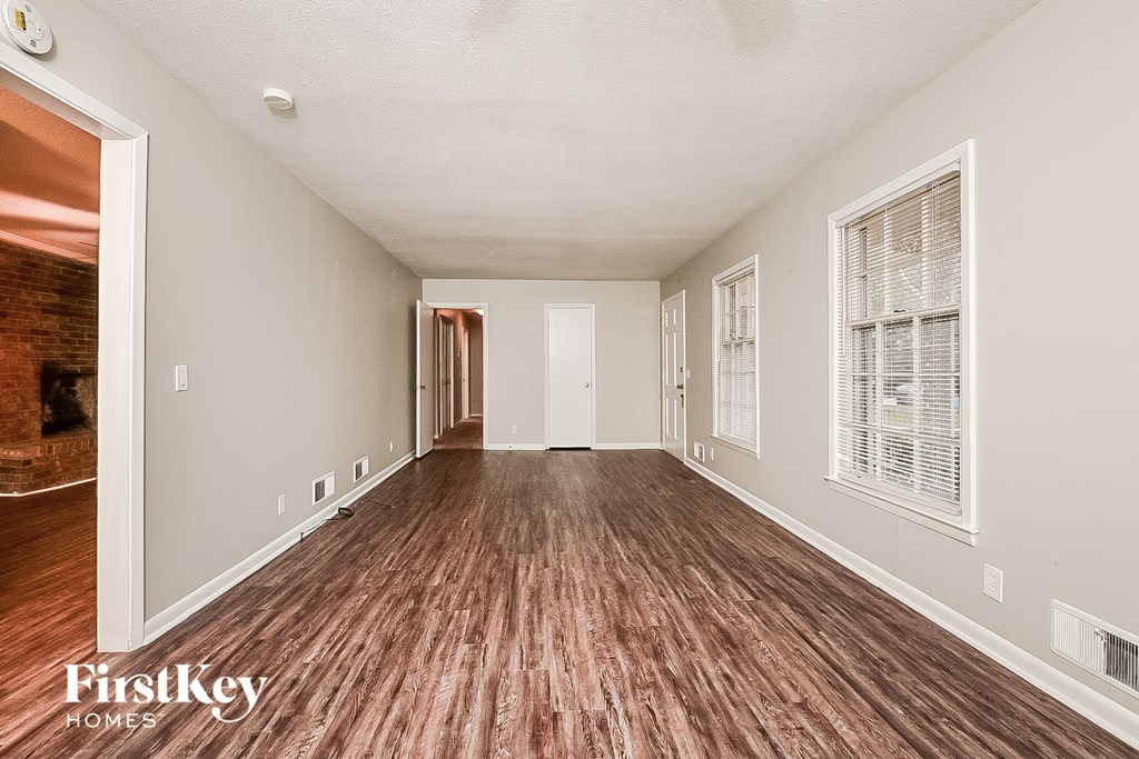 a spacious living room with wood flooring and a large window