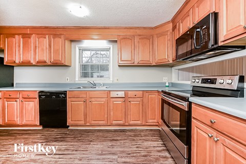 a kitchen with wooden cabinets and black appliances