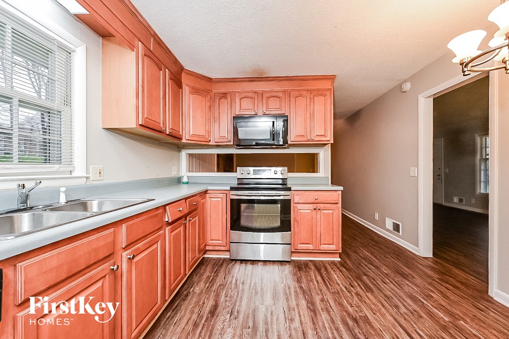 a kitchen with wood flooring and wooden cabinets