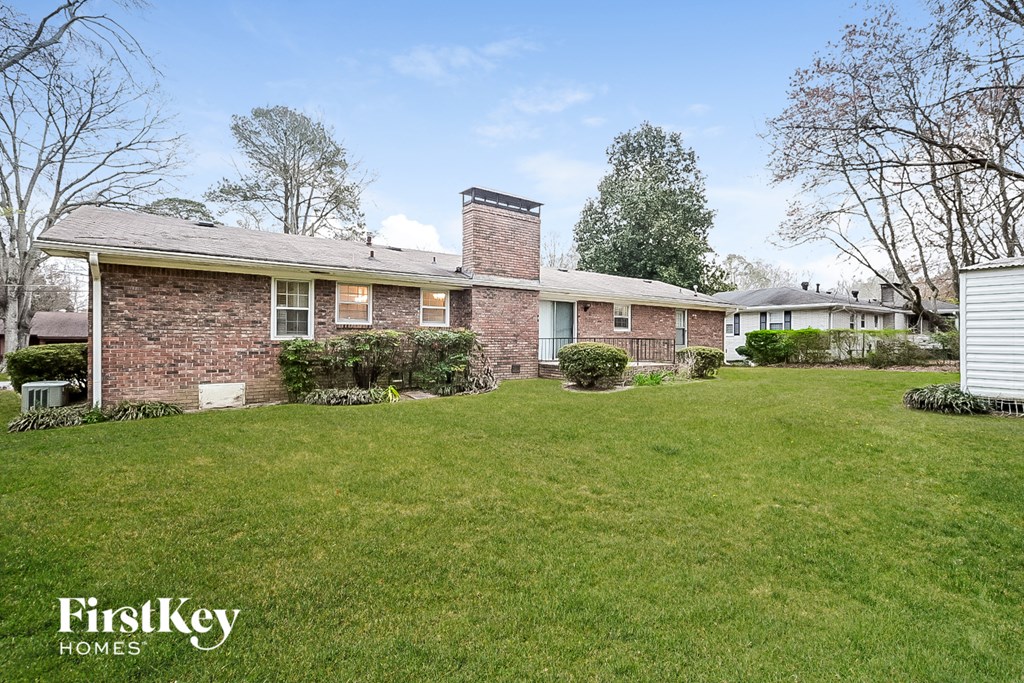 a brick house with a green lawn in front of it