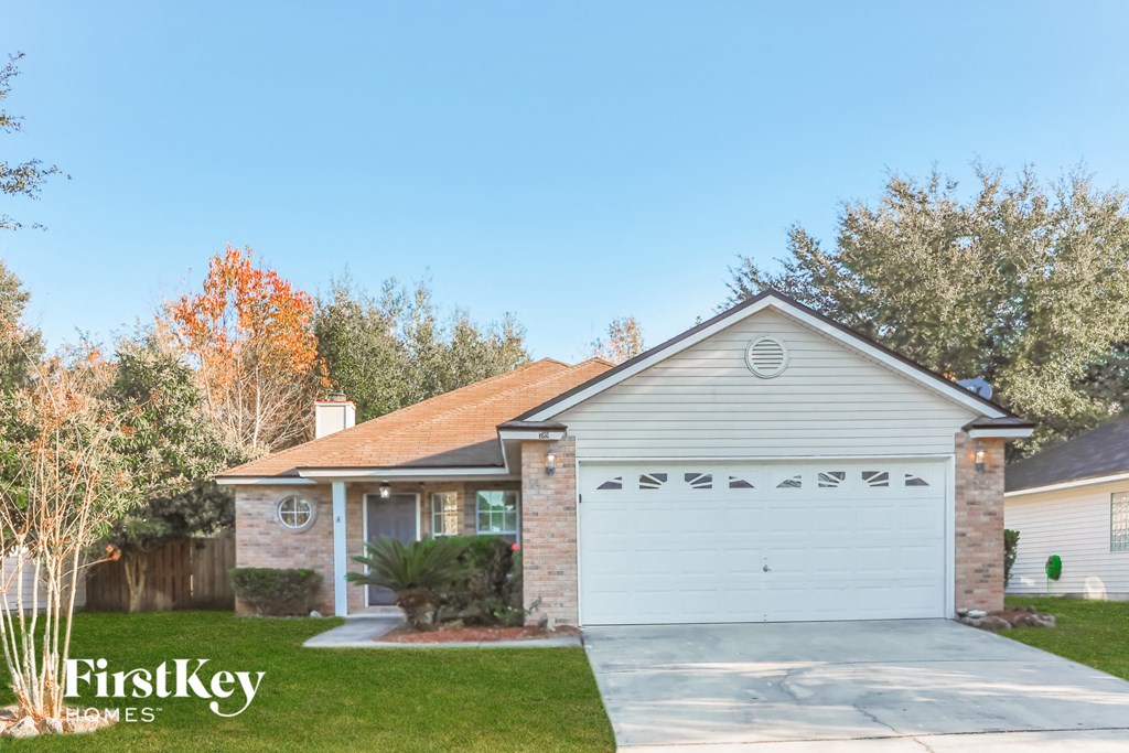 a home with a white garage door and a brick house