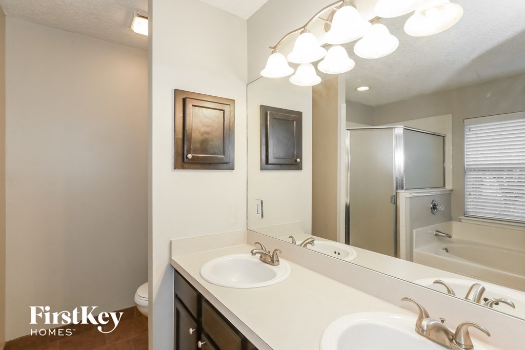 a bathroom with two sinks and a mirror and a shower