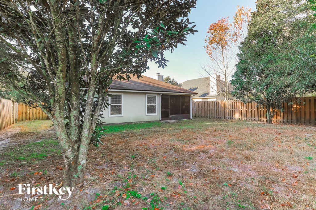 a backyard with a small white house and a tree