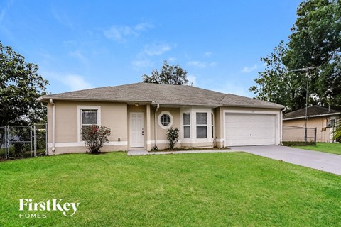 a beige house with a lawn in front of it