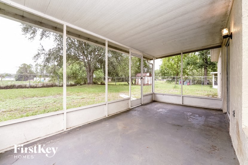 a screened in porch with a view of the yard