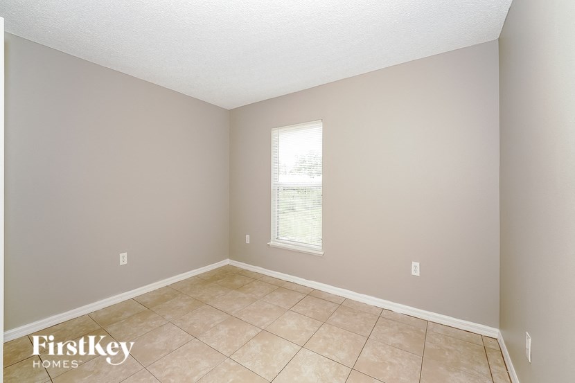 a empty room with a window and a tiled floor