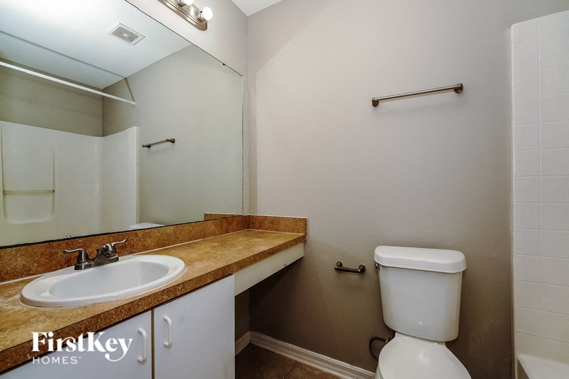 a bathroom with a sink toilet and a mirror