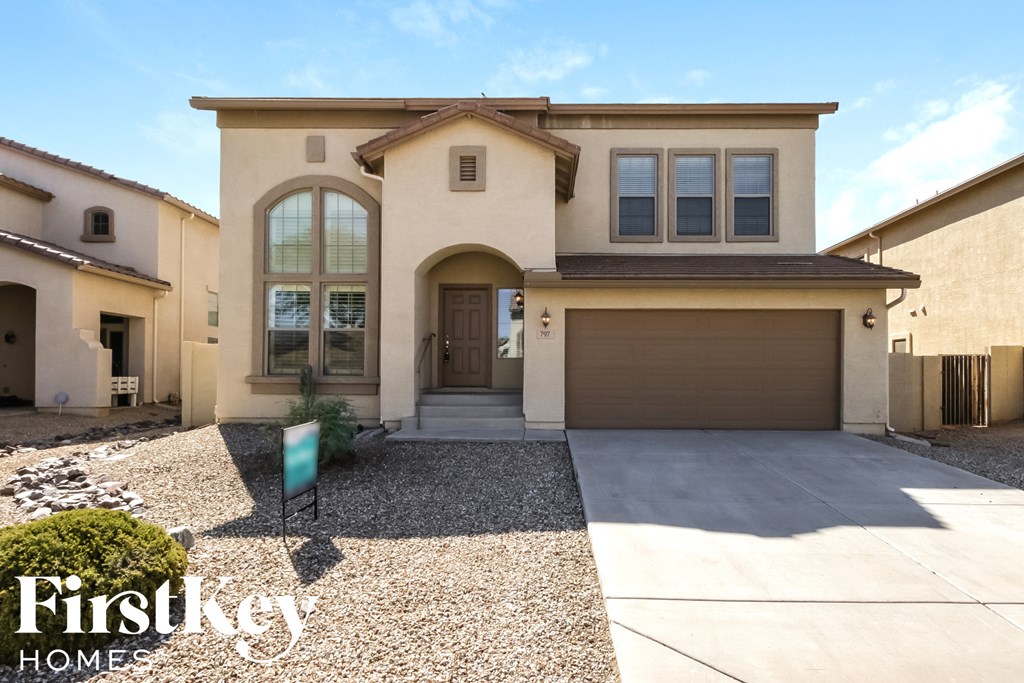 A house with a garage and a driveway in front of it.