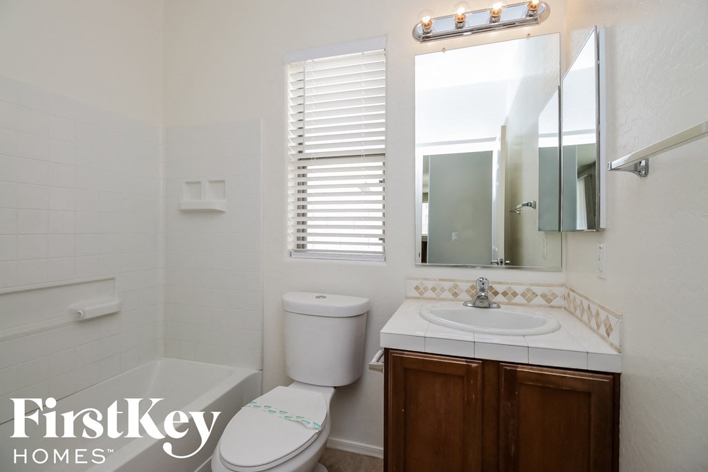 A white toilet sits next to a sink in a small bathroom.