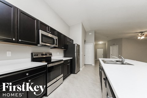 a kitchen with black cabinets and white counter tops and a sink
