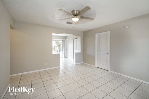 A spacious room with a ceiling fan and tile flooring.