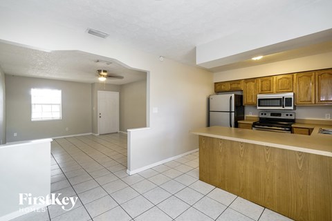 A kitchen with wooden cabinets and a white fridge.