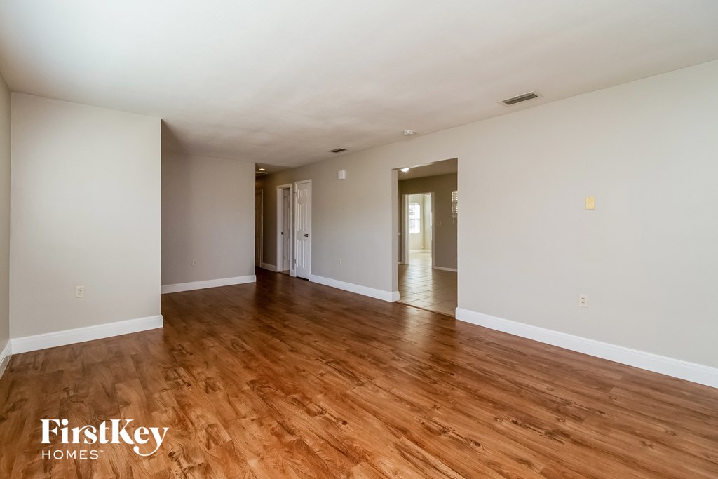 a living room with wood floors and white walls