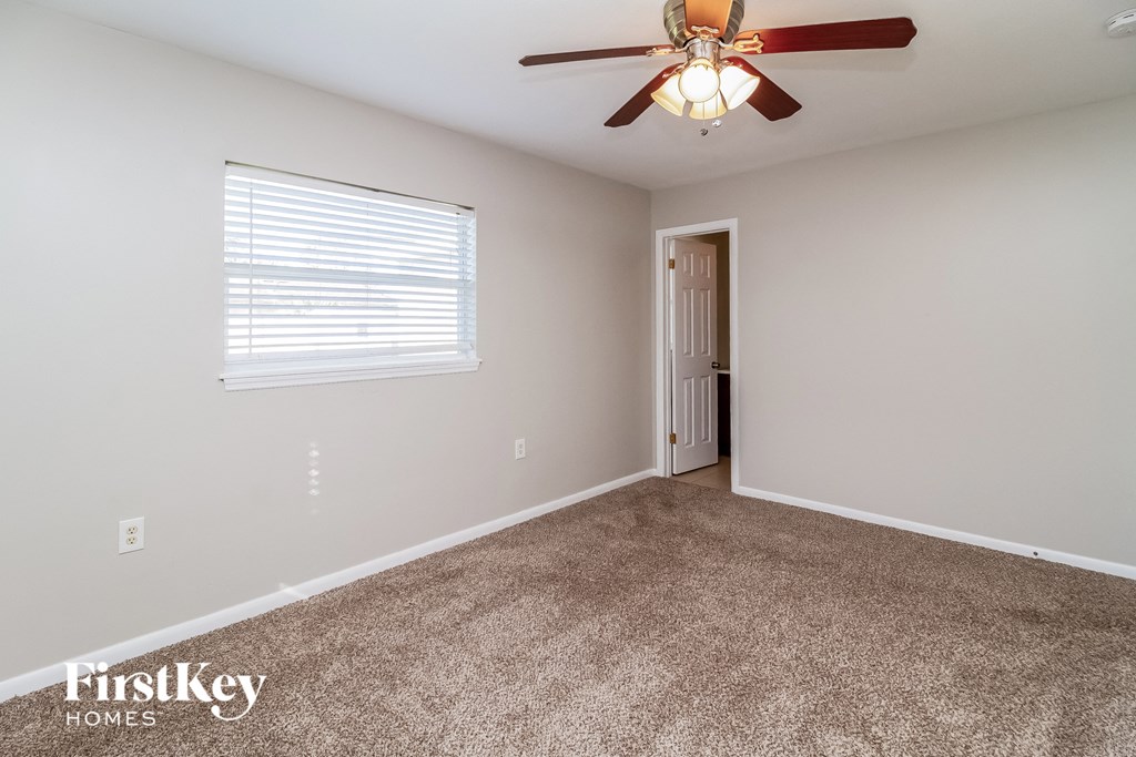 a bedroom with a ceiling fan and a carpeted floor