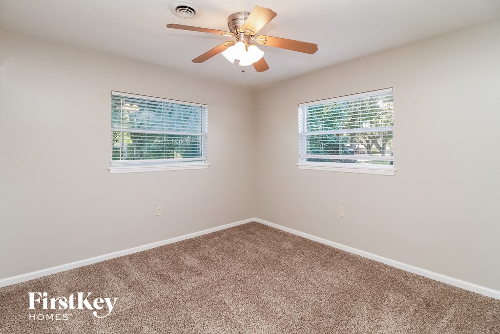 the master bedroom has a ceiling fan and two windows