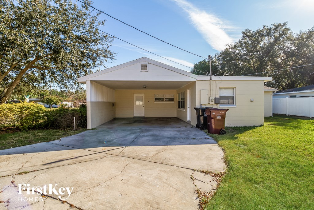 a small white house with a driveway and a yard