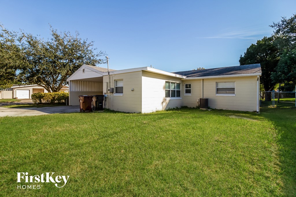 a small white house with a yard and a lawn