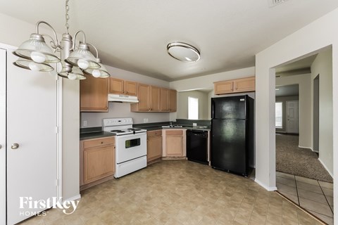 A kitchen with a white fridge and black dishwasher.