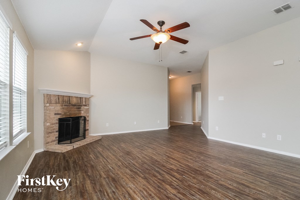 a living room with a fireplace and a ceiling fan