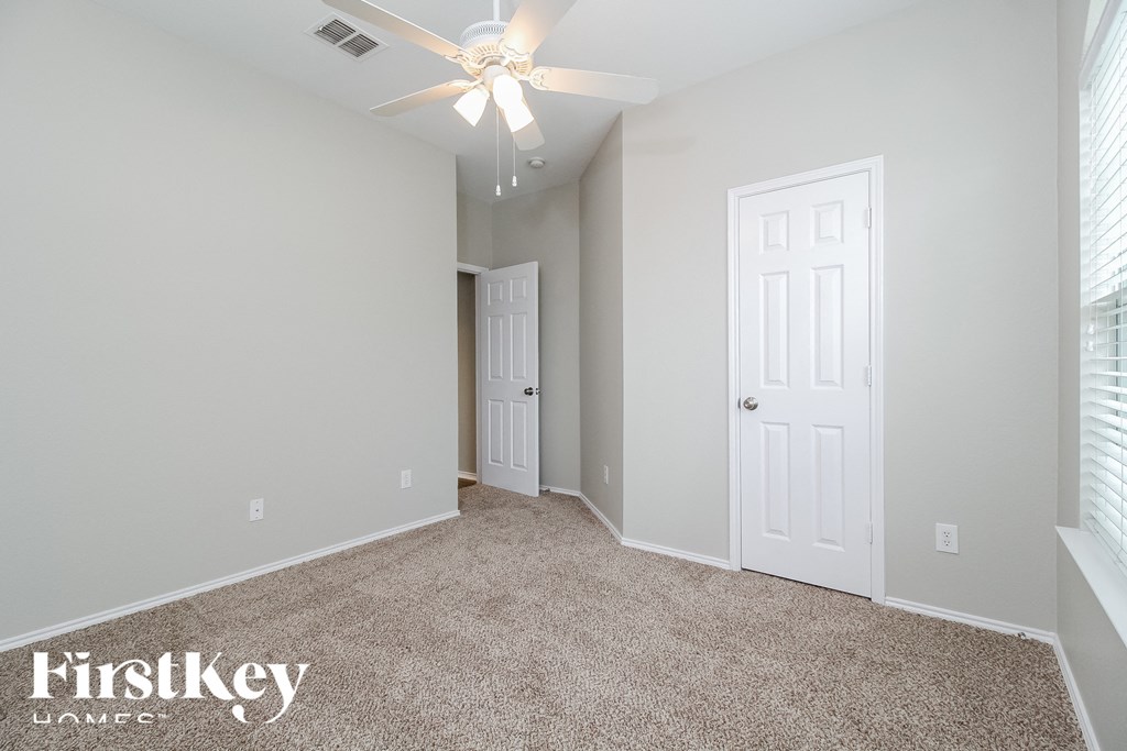 a bedroom with a carpeted floor and a ceiling fan
