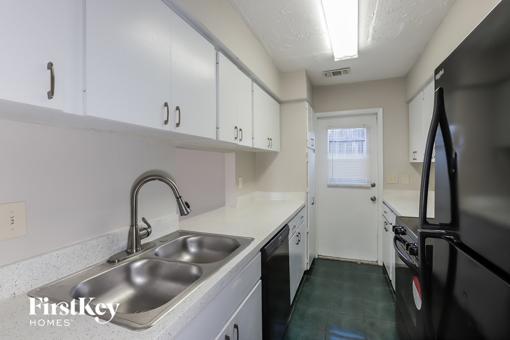 A kitchen with a sink and a refrigerator.