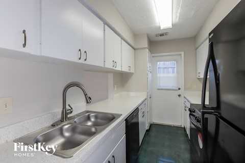 A kitchen with a sink and a refrigerator.