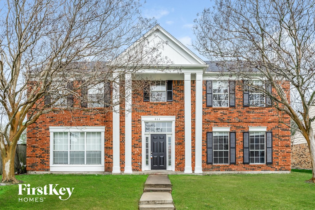 a red brick house with black shutters and a black door