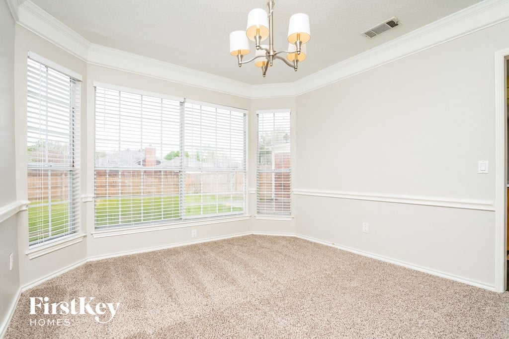 a dining room with a chandelier and large windows