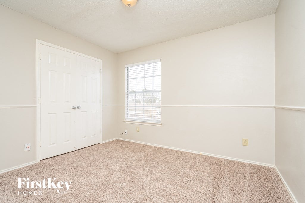 a bedroom with white walls and carpet and a white door