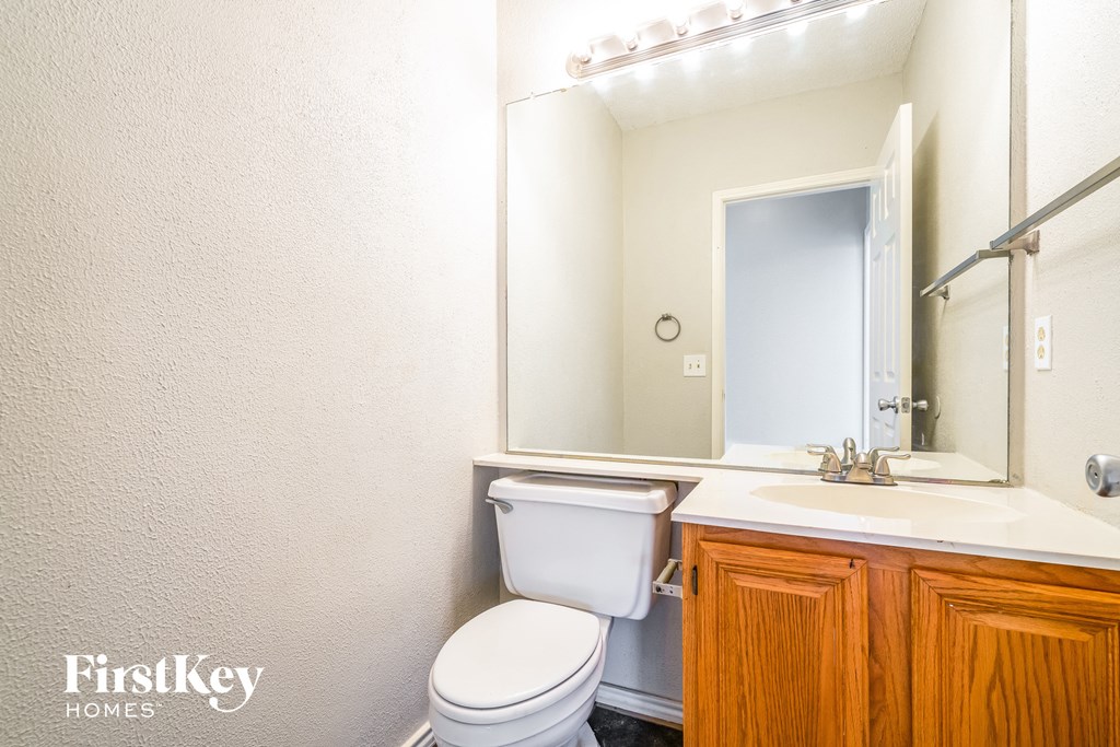 a bathroom with a toilet sink and a mirror