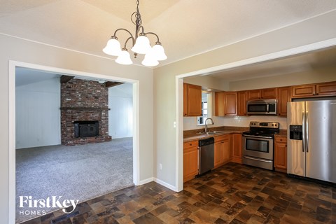 A kitchen with wooden cabinets and a stone fireplace.