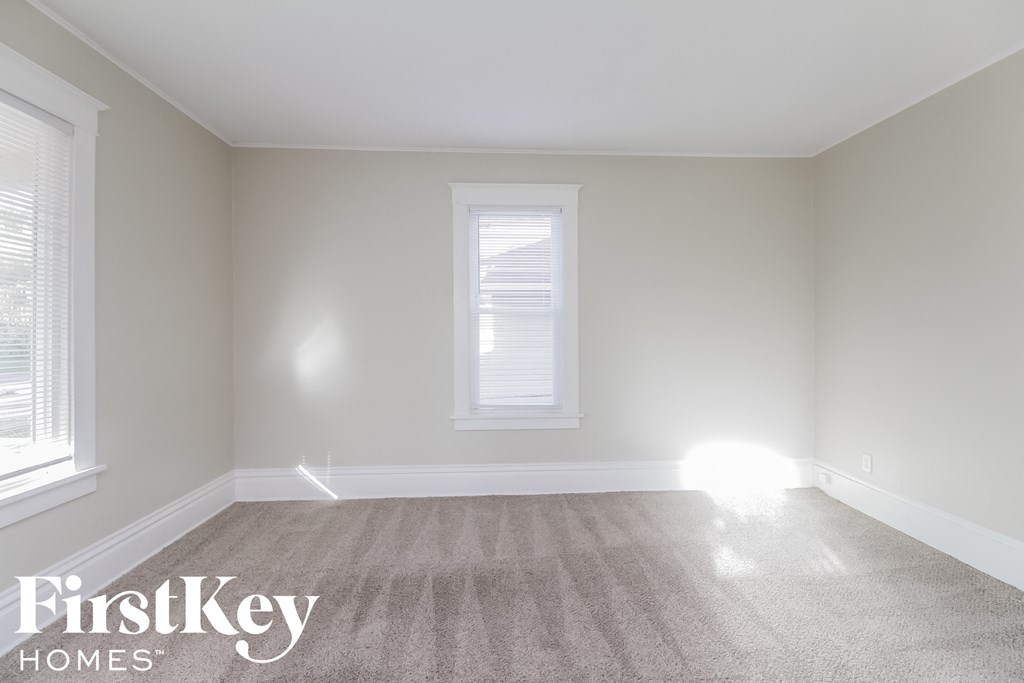 A room with a carpeted floor and a window.