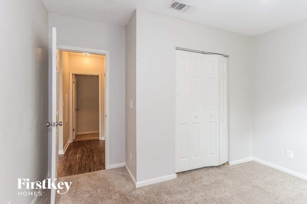 a bedroom with a closet and a door to a hallway