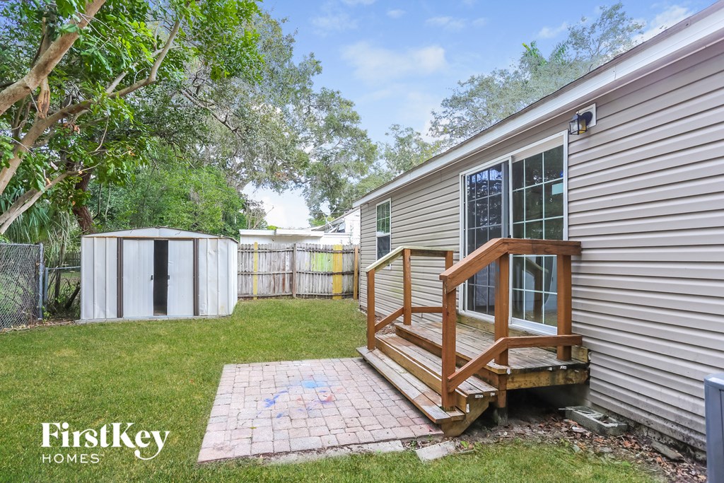 a backyard with a deck and a house