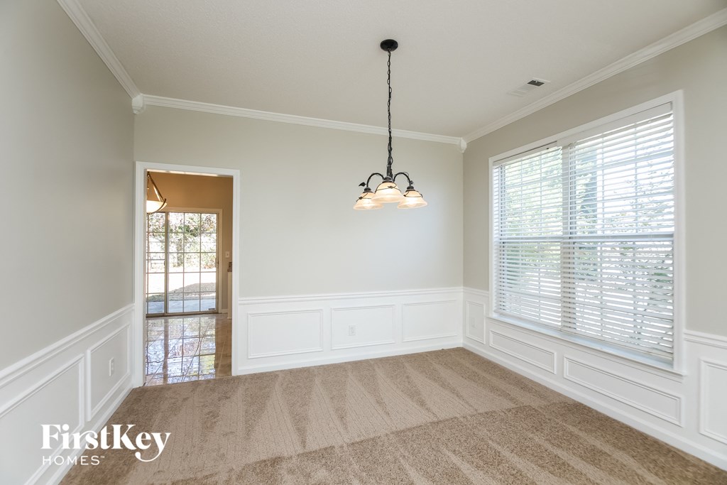 an empty dining room with two windows and a chandelier