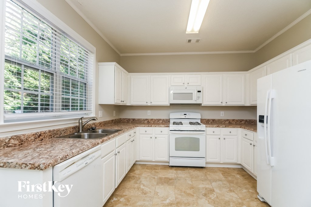 a kitchen with white appliances and granite counter tops