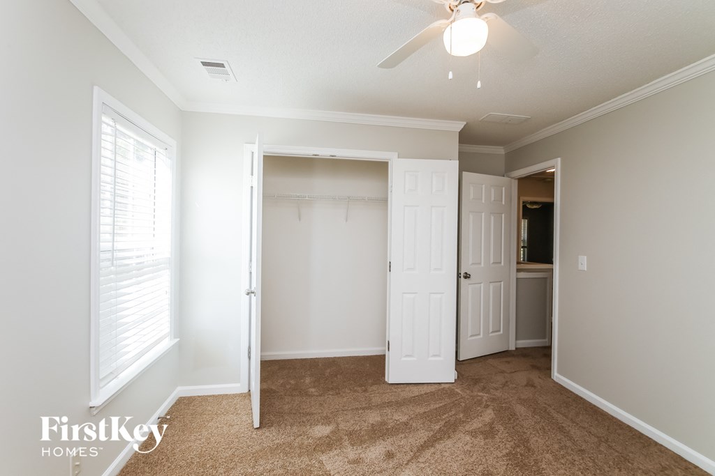 a bedroom with a closet and a ceiling fan