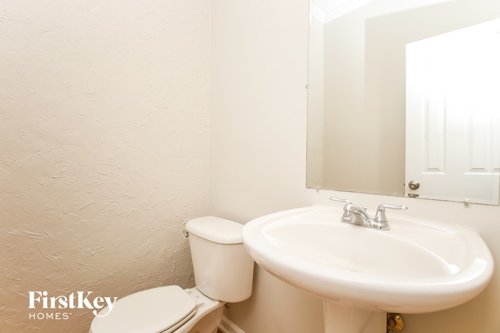 a bathroom with a sink and toilet and a mirror