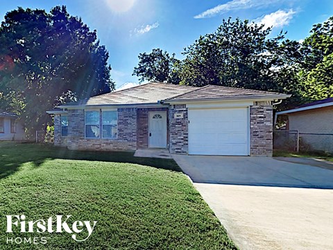 a small brick house with a white garage door