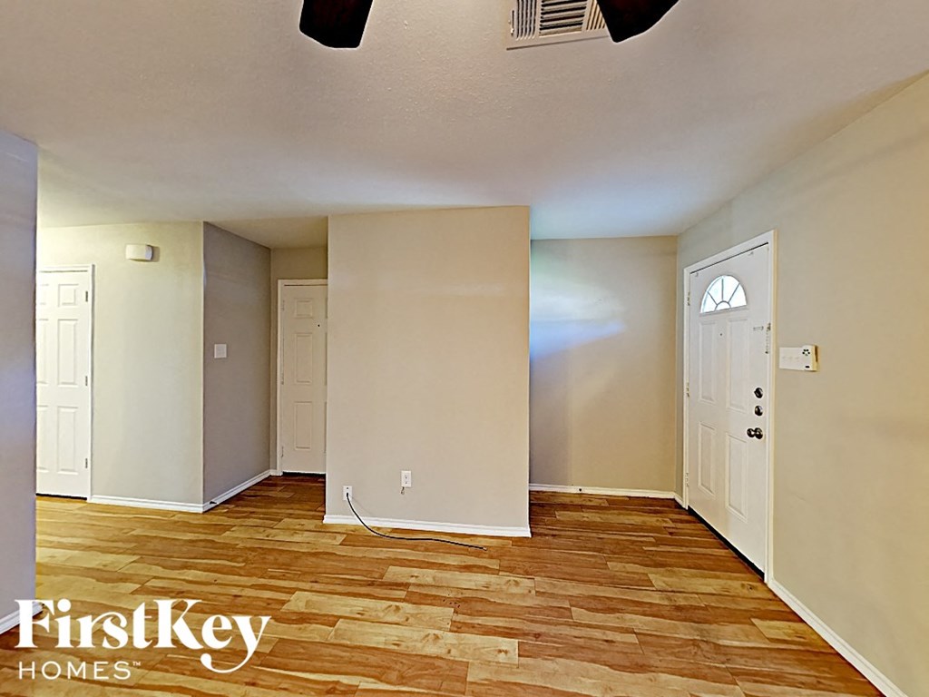 an empty living room with wood floors and a white door