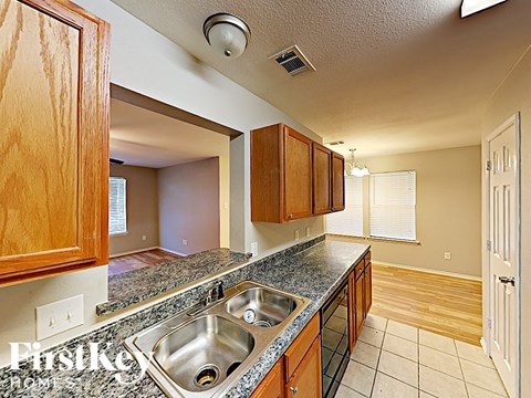 a kitchen with granite counter tops and a stainless steel sink