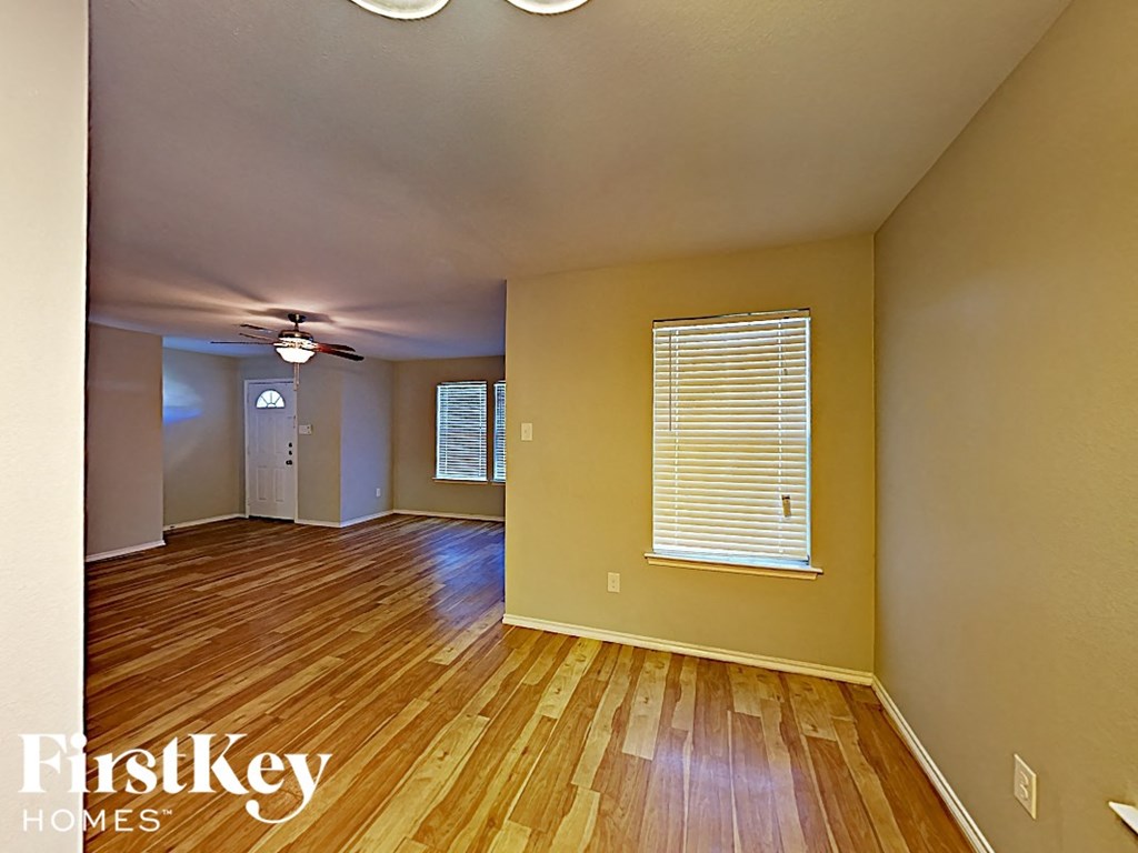 the living room and dining room of an empty house with wood floors