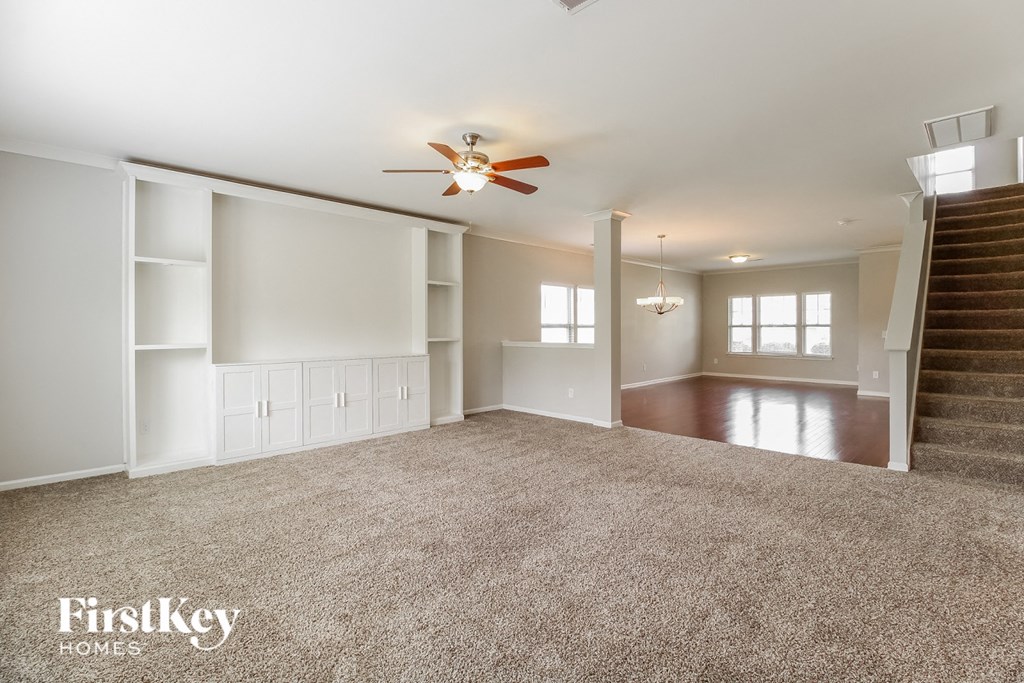 A spacious living room with a staircase leading to the upper floor.