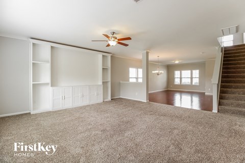 A spacious living room with a staircase leading to the upper floor.