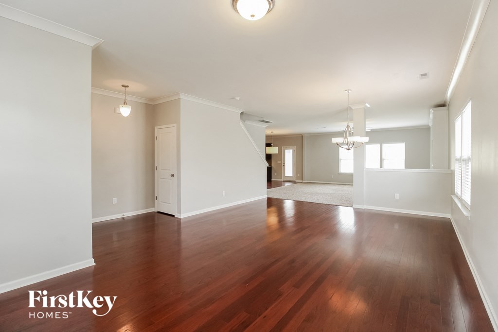A spacious room with wooden floors and white walls.